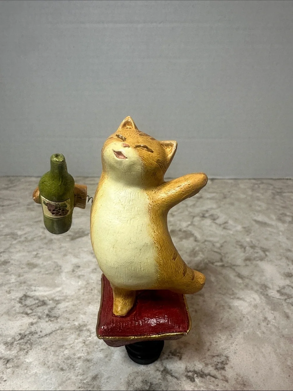 Yellow Cat Figurine Holding Bottle on Red Cushion- Bottle Stopper